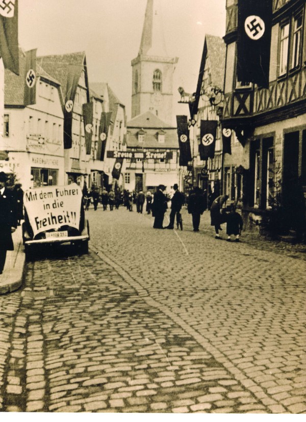 Wahlkampf in Lohr 1938 – Blick in den unteren Teil der „Adolf-Hitler-Strae“ (Hauptstrae). Bemerkenswert die Wahlslogans: „Mit dem Fhrer in die Freiheit“, „Treue um Treue“.