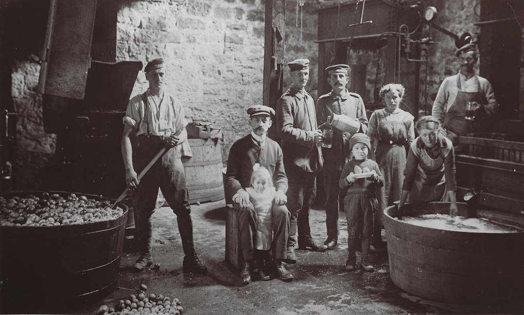 Foto 1918: Keltern von Apfelmost im der Scheune des Gasthauses „Zur Rose“; in der Bildmitte der Gastwirt der Rose Adolf Mayer mit Tochter Gertrud.