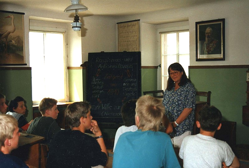 Monika Stenger unterrichtet eine Schulklasse im Klassenzimmer aus der Zeit um 1910