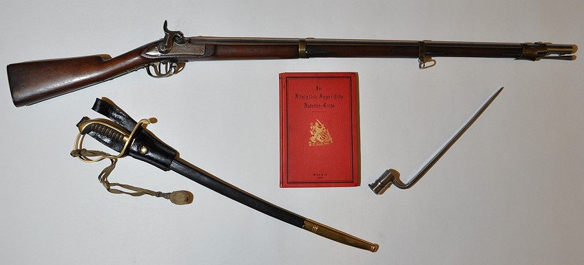 Waffen des bayerischen Kadetten-Corps: Kadettengewehr mit Bajonett um 1845, Kadettensbel („Elevensbel“) aus der Regierungszeit Knig Ludwigs I. (1825-1848) und vorderer Einbanddeckel des Buches „Das Kniglich Bayerische Kadetten-Corps, von Friedrich Teicher, Mnchen 1889“