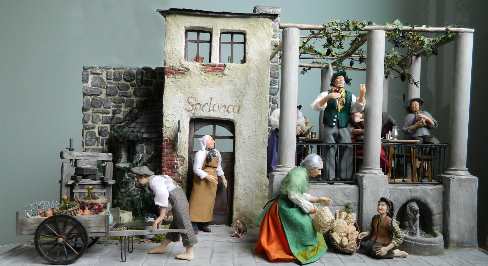 In der italienischen „Spelonca“ vergnügt man sich beim Wein. Die weinselige frohe Stimmung ist auf der Vorderseite, die trübselige Verfassung  nach übertriebenem Alkoholgenuss ist auf der Rückseite der Szene dargestellt.