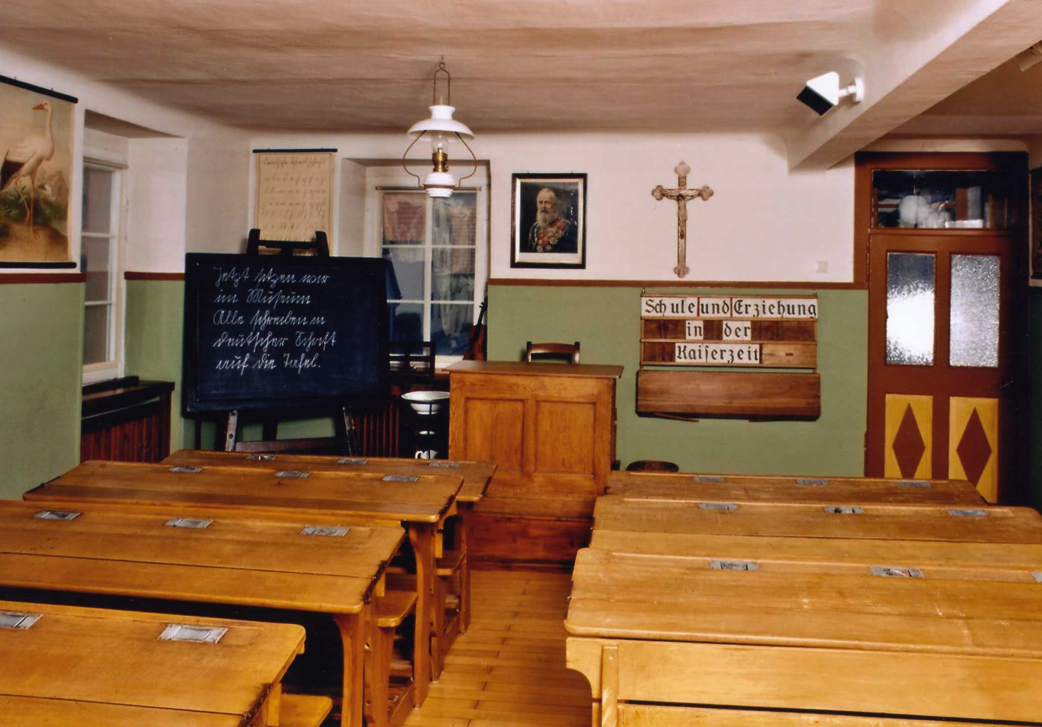 Klassenzimmer um 1900 in der stndigen Ausstellung des Lohrer Schulmuseums: ber dem erhhten Lehrerpult hngt das Bild des Landesfrsten und das Kruzifix. - „Thron und Altar“ bestimmten den Lebensablauf des Lehrers. (Foto: Kleinfelder, Lohr a.Main)