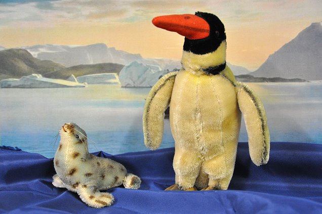 kleiner Seelöwe und Pinguin der Firma Steiff vor Schulwandbild „Antarktis“